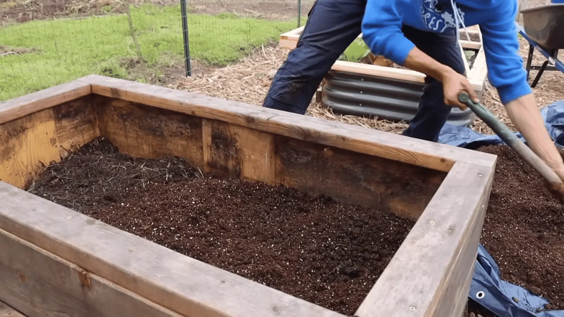 adding potting soil mix over compost in a planter a step in how to fill raised garden beds